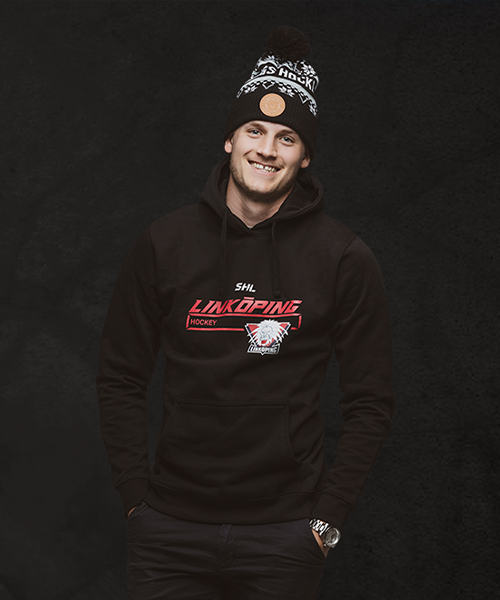 Känd svensk hockeyspelare poserar med sin klubbtröja