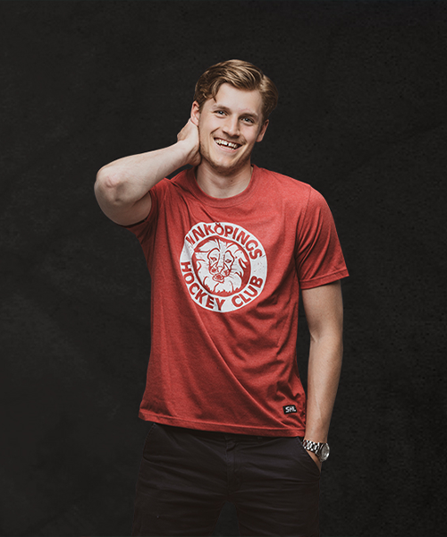 Känd svensk hockeyspelare poserar med sin klubbtröja